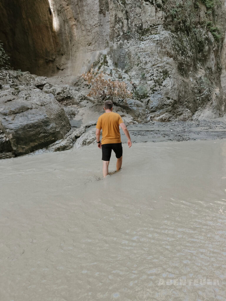 Person in heißer Quelle bei Felsen, Naturerlebnis in Österreich.