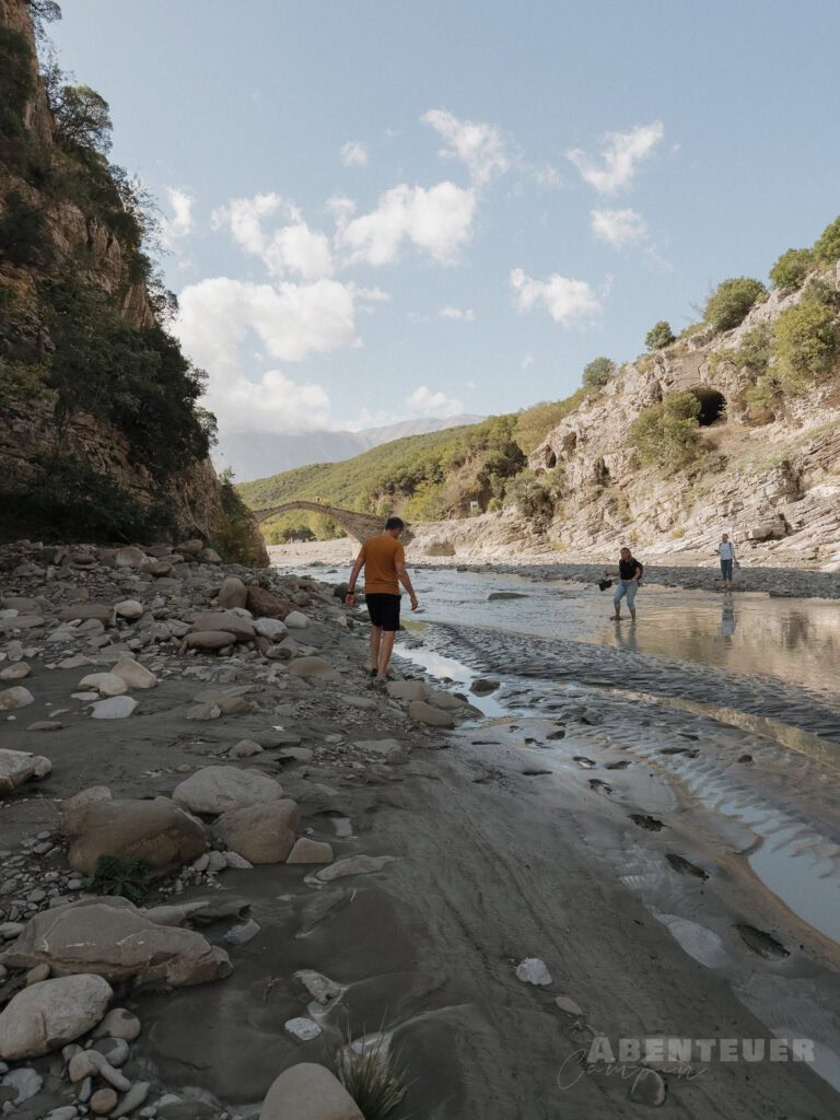 Heiße Quellen in der Natur, umgeben von Bergen und Fluss, ideal für Abenteuercampen.