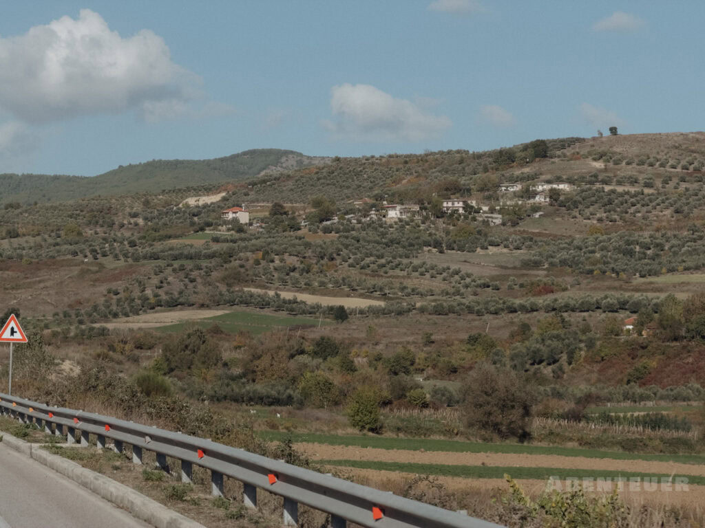 Landschaft mit Hügeln, Feldern und einem Roadtrip bei heißen Quellen in Österreich.